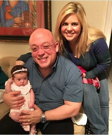Armando Paz Jr., Jackie Paz, and their infant daughter smiling